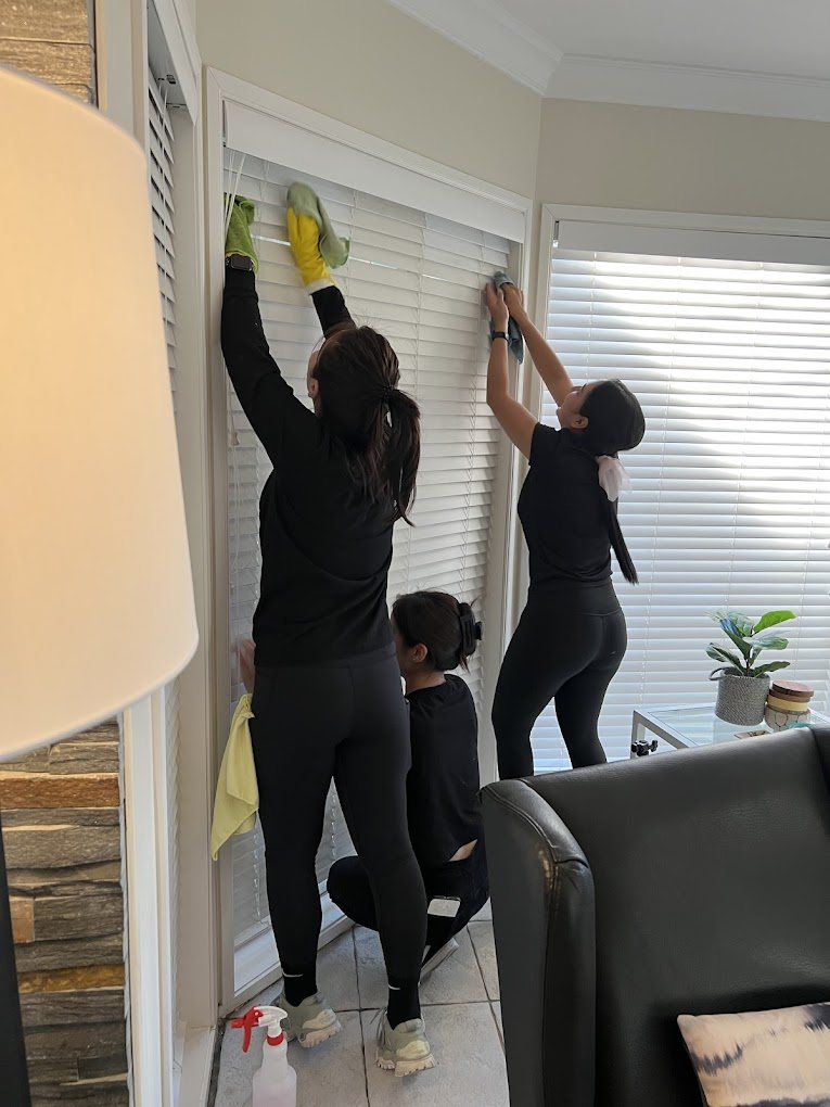 M&I team members detail-cleaning blinds, window frames and skirting boards