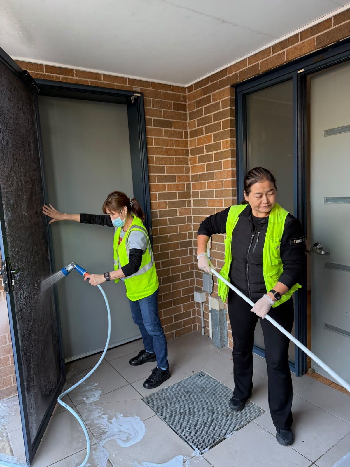 M&I cleaners washing down a townhouse entry and screen door