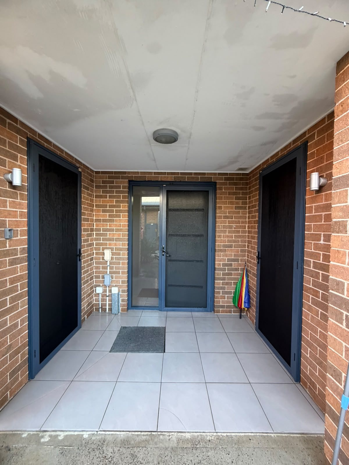 Covered townhouse entry with tiled common area, cleaned