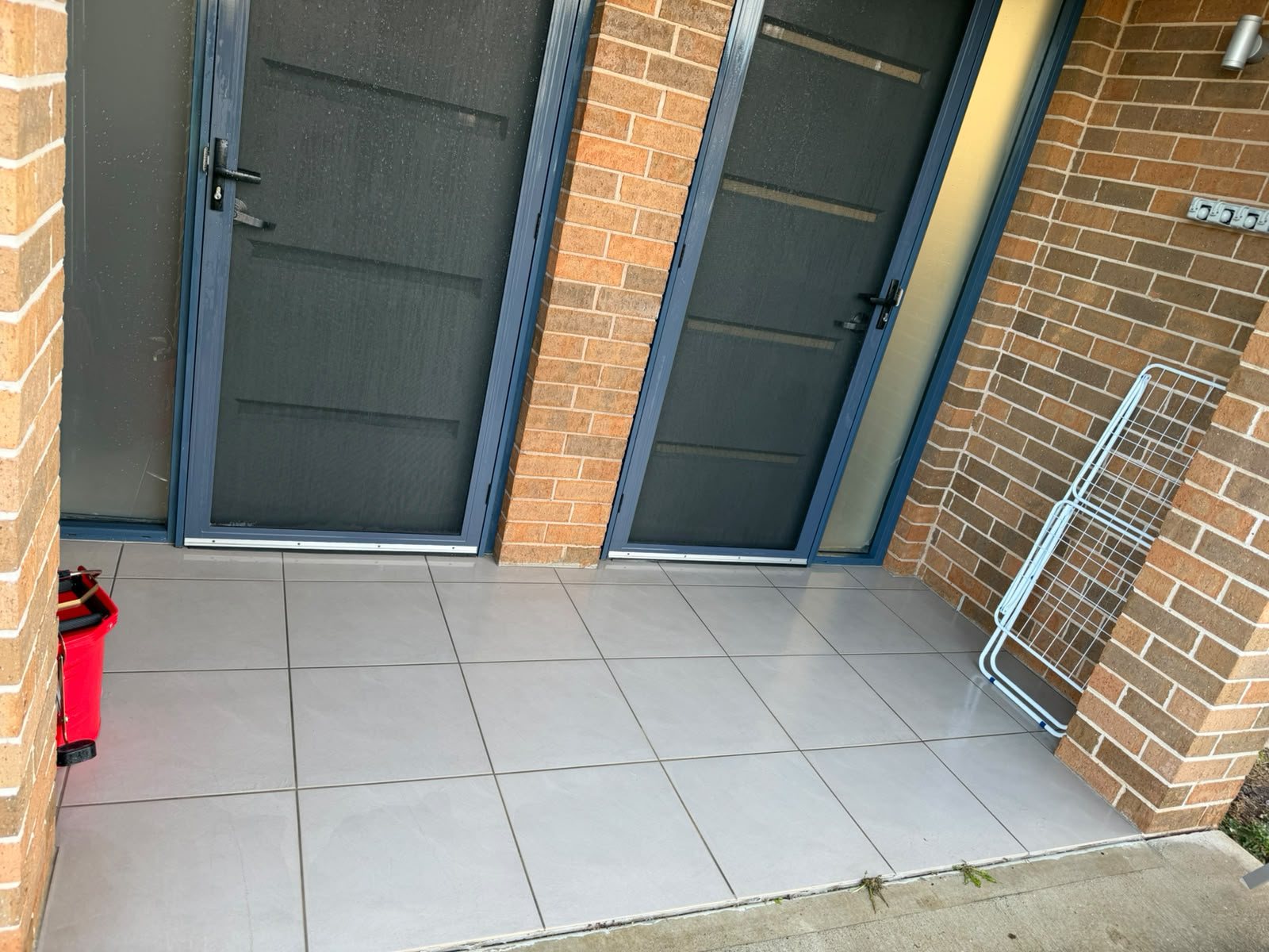 Tiled courtyard and screen doors in a townhouse complex, cleaned
