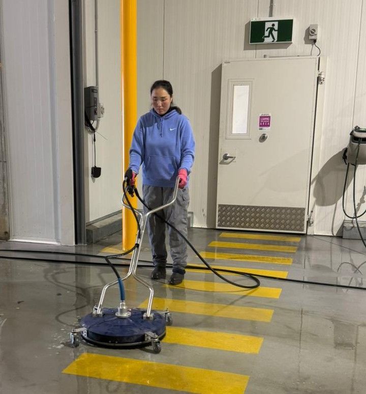 M&I cleaner pressure-washing a warehouse floor